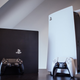a playstation 4 and a playstation 5 on a brown table in a white room
